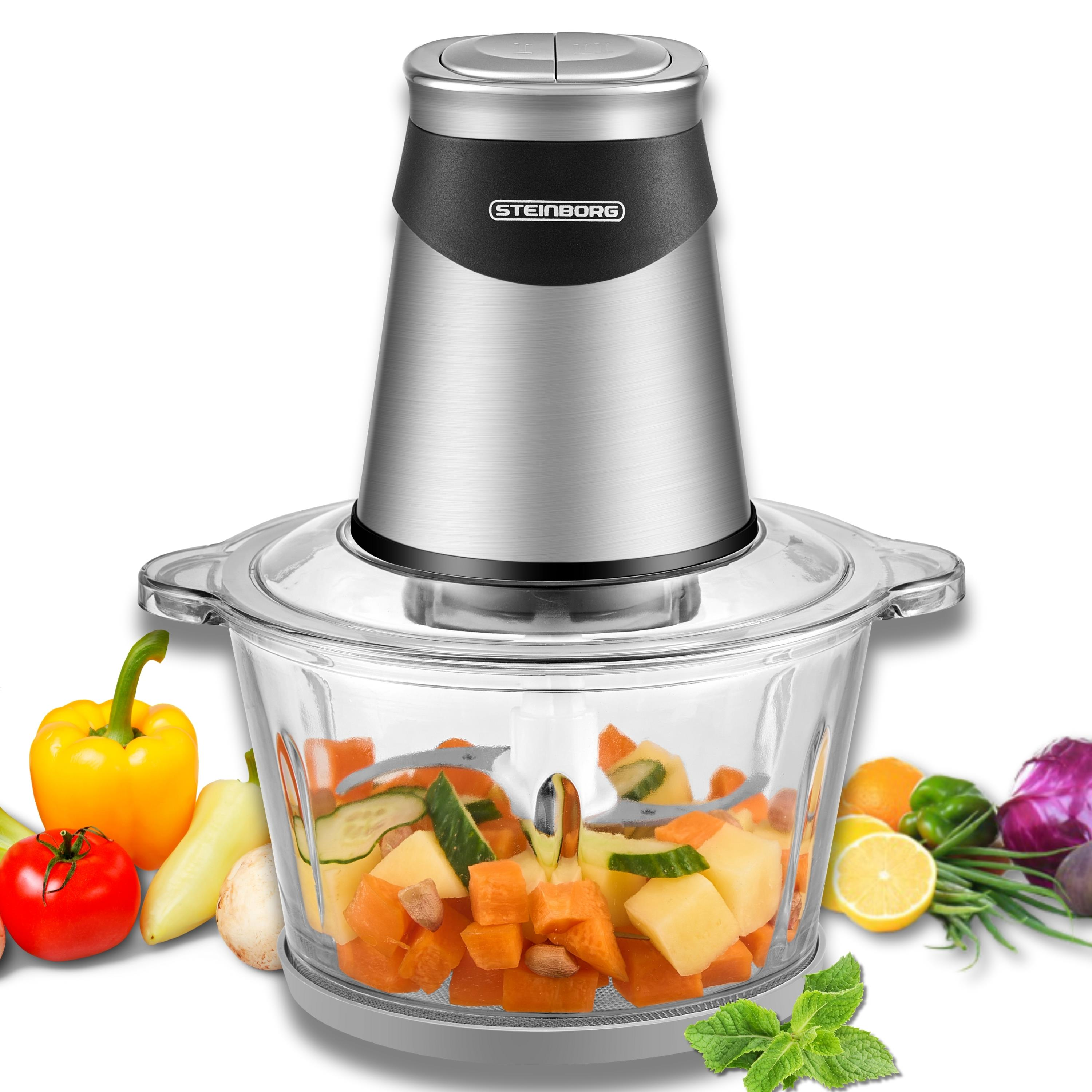 Ein Food-Prozessor mit Gemüse. Gehackte Karotten, Gurken und anderes Gemüse sind in einer Glasschüssel.