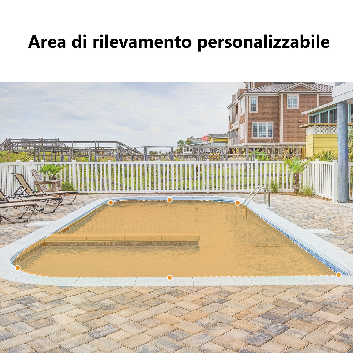 Basen otoczony płotem ma żółto-brązowy odcień. Leżaki po lewej stronie. Budynki widoczne w tle.