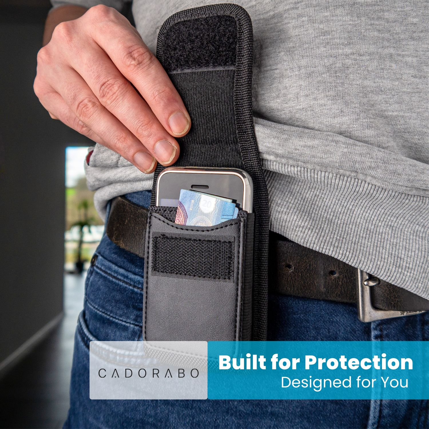 Eine Person hält ein Telefon in einer schwarzen Hülle an ihrem Gürtel. Geld ist in der Telefontasche sichtbar. Der Text "Built for Protection" erscheint.