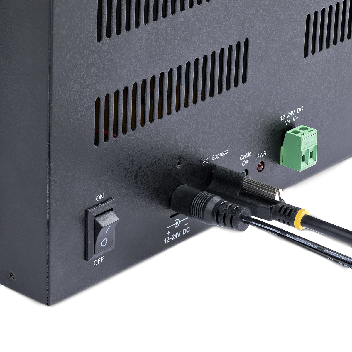 Primer plano de la parte trasera de un dispositivo electrónico negro con cables enchufados, un interruptor y un conector verde.