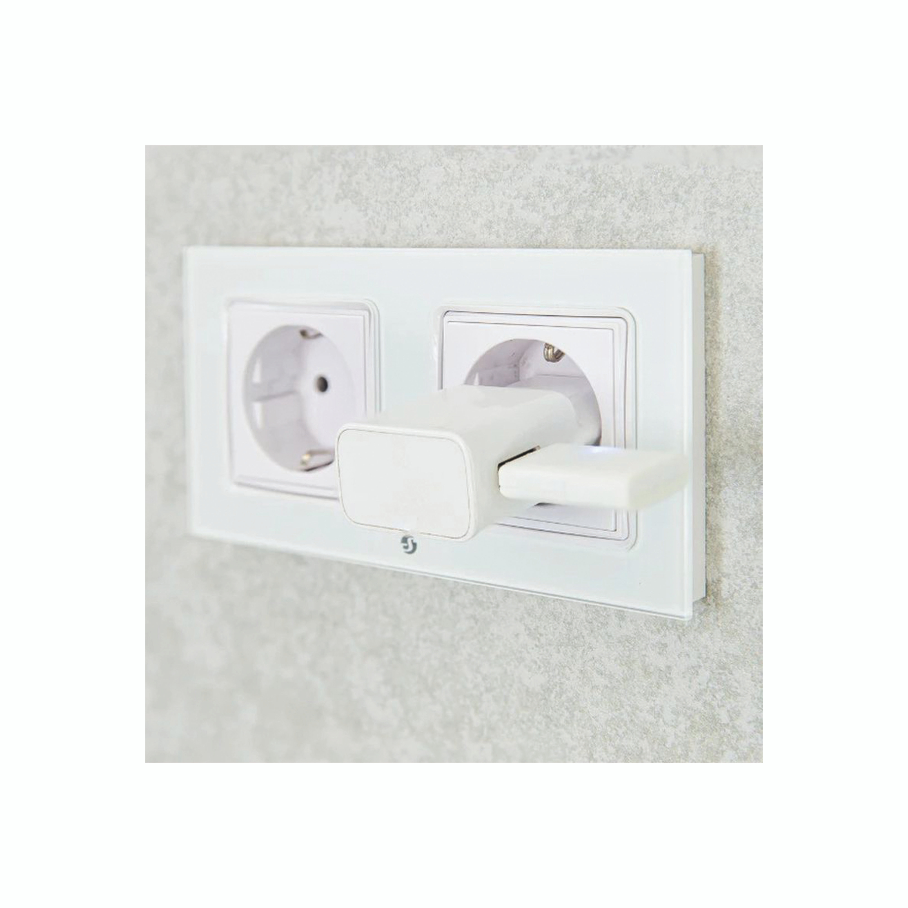 Prise électrique blanche avec un adaptateur blanc branché, sur un mur gris texturé.