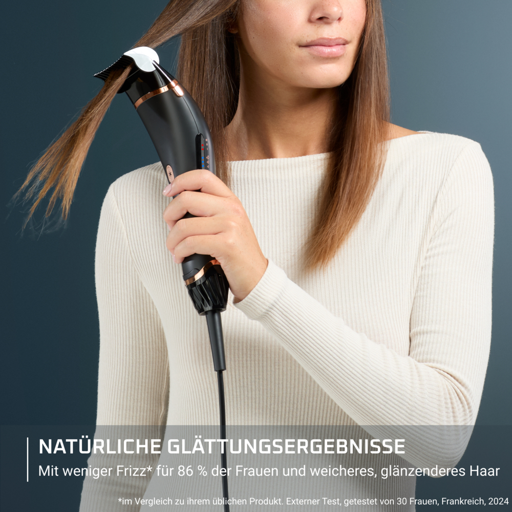 Een vrouw houdt een zwart en koperkleurig haarstylingtool vast, waarmee ze haar haar steilt. Ze draagt een crème-kleurige trui. Blauwe achtergrond.