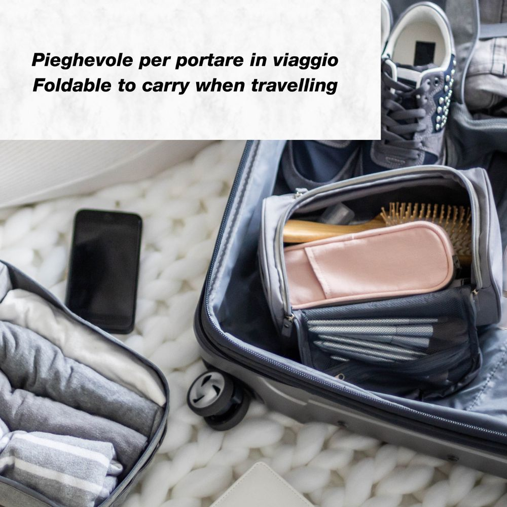 Valigia aperta con articoli da toilette, scarpe, vestiti e smartphone su una coperta bianca a maglia. Testo: 'Pieghevole per viaggiare'.