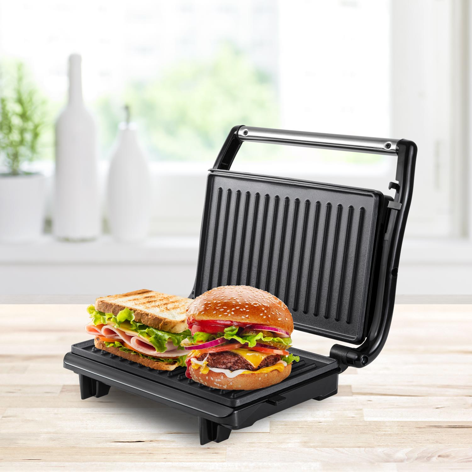 Un sandwich e un hamburger su una griglia nera. Il sandwich ha prosciutto e lattuga. L'hamburger ha formaggio e verdure.