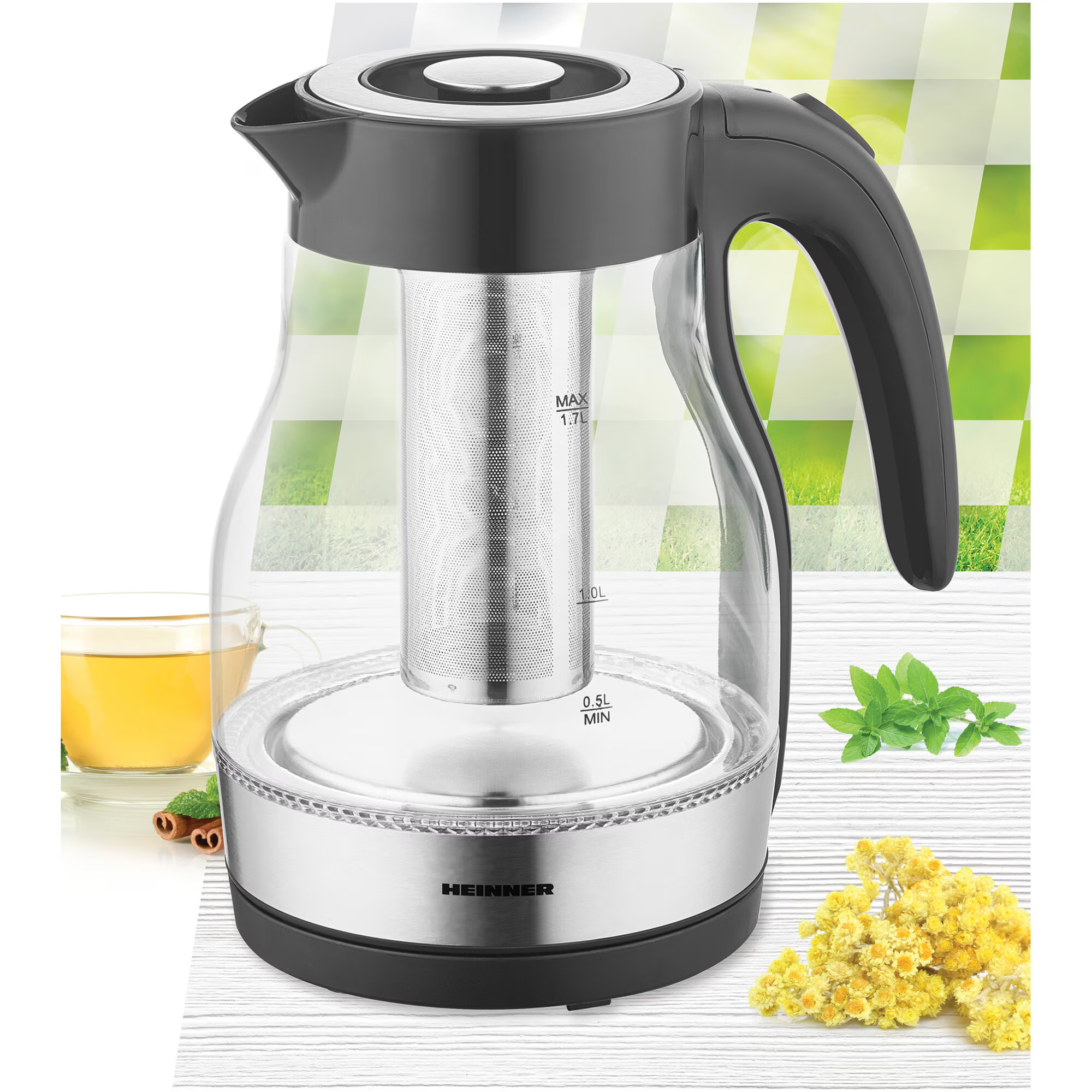 Glazen waterkoker met thee-infuser, een kopje thee en kruiden. De achtergrond heeft een groen en wit patroon.