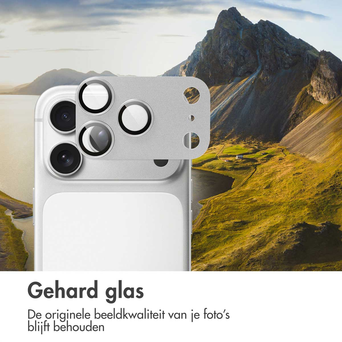 Un téléphone avec un protecteur d'objectif, sur fond de paysage de montagne. Le téléphone est argenté, le fond présente des montagnes et de l'eau.