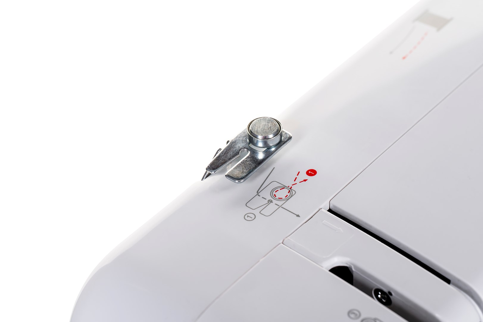 Zbliżenie białej maszyny do szycia. Widoczna jest metalowa stopka dociskowa i schemat instrukcji nawlekania.