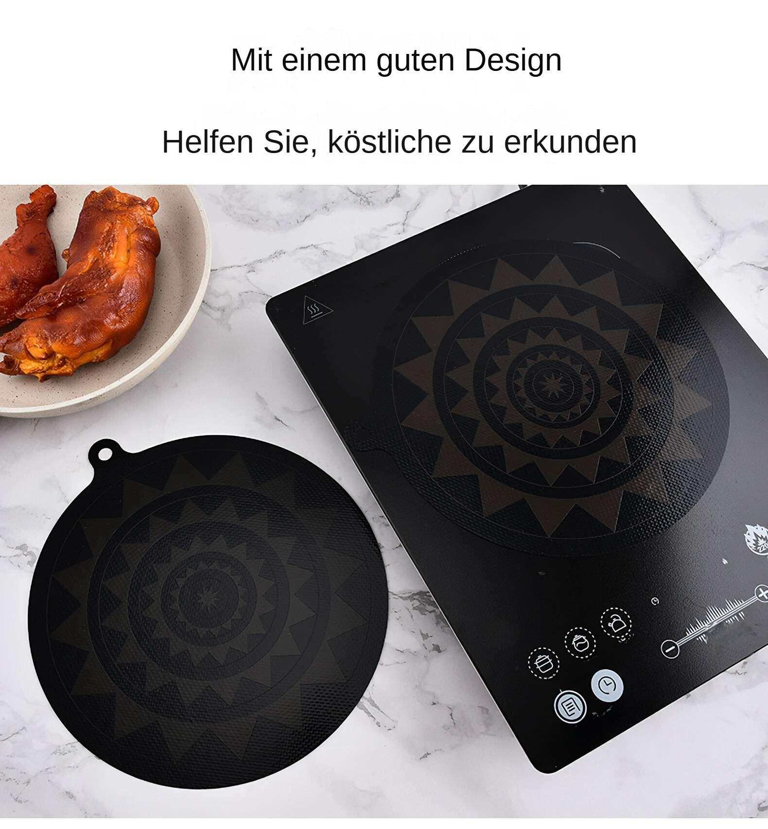Ein schwarzes Induktionskochfeld mit Design, eine schwarze Matte und Essen auf einem weißen Teller auf Marmor.