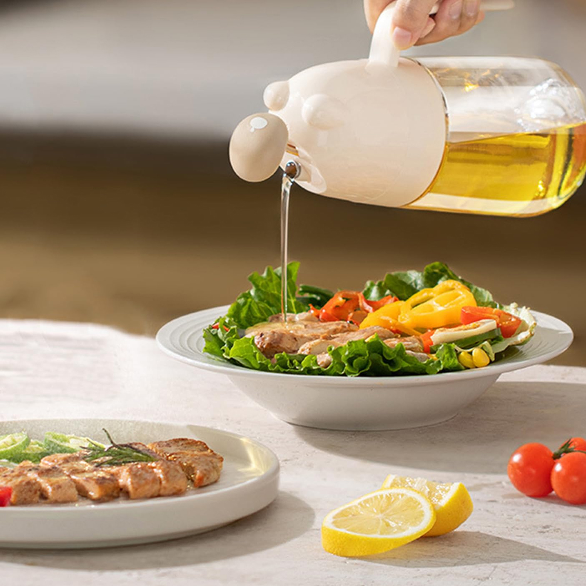 Öl wird aus einem bärenförmigen Spender über Salat geträufelt. Salat, Grillfleisch, Tomaten und Zitronenscheiben auf einem Tisch.
