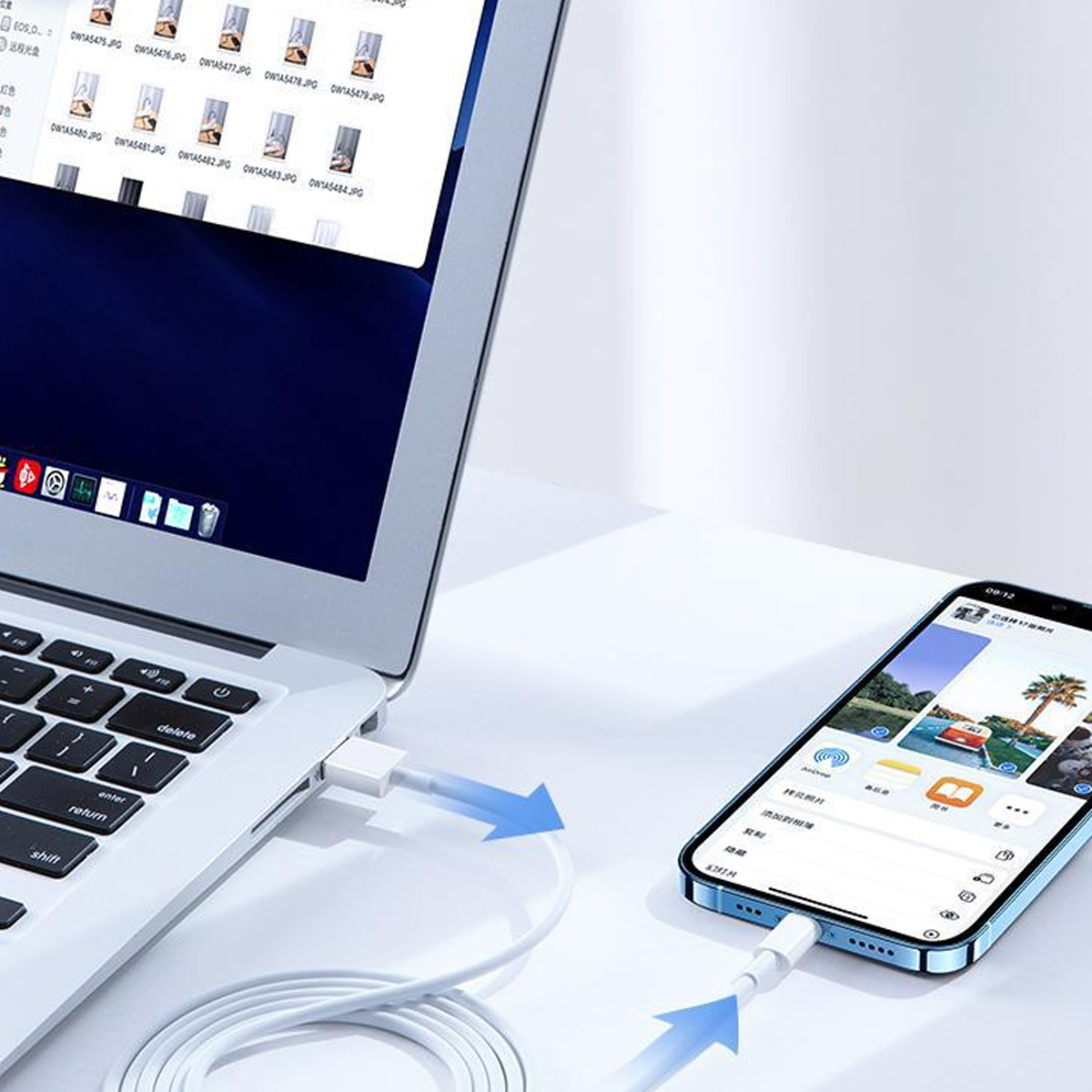 Laptop und Smartphone mit weißem Kabel verbunden. Der Laptop-Bildschirm zeigt Dateien, das Telefon eine App.