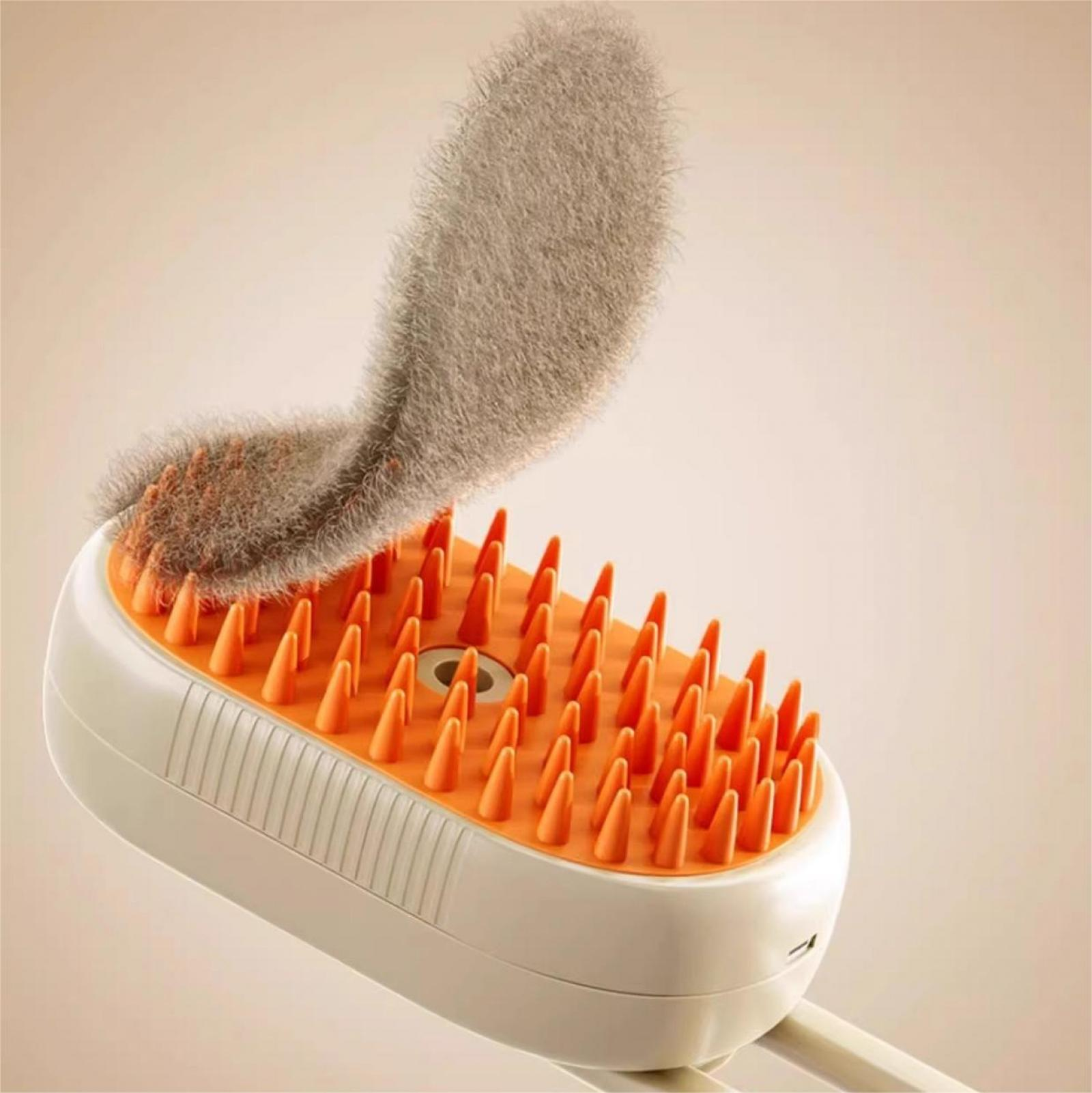 Eine Pflegebürste mit orangefarbenen Stacheln und einem grauen, flauschigen Pad. Die Bürste ist weiß und der Hintergrund beige.
