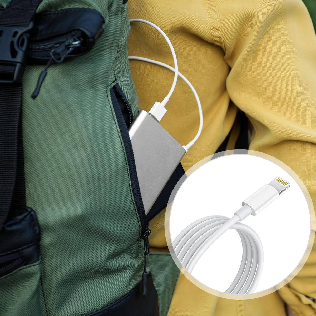 Eine Person mit grünem Rucksack lädt eine silberne Powerbank auf. Ein weißes Ladekabel ist eingesteckt.