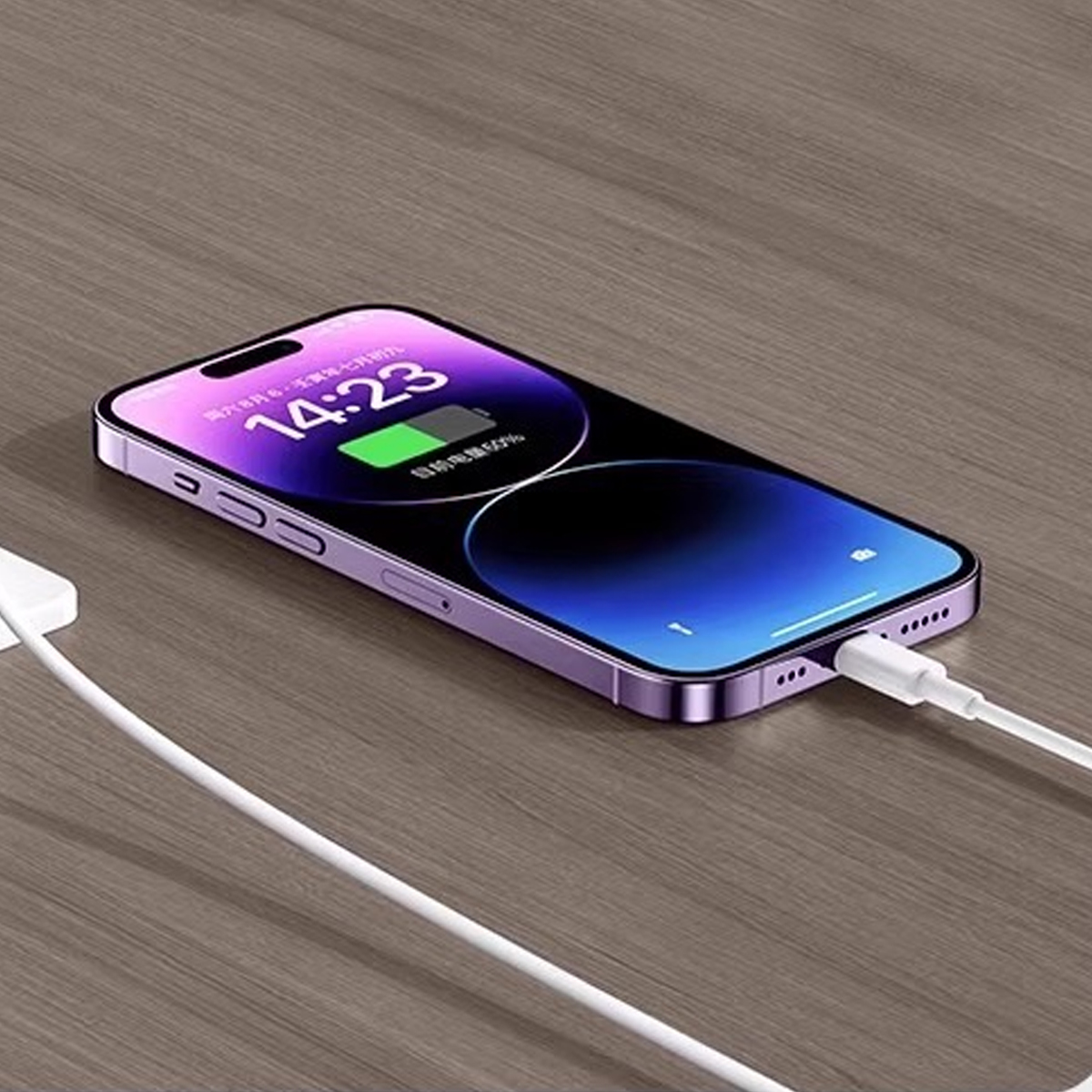 Ein lila iPhone wird auf einem Holztisch aufgeladen. Der Bildschirm zeigt die Uhrzeit. Ein weißes Kabel ist mit dem Telefon verbunden.