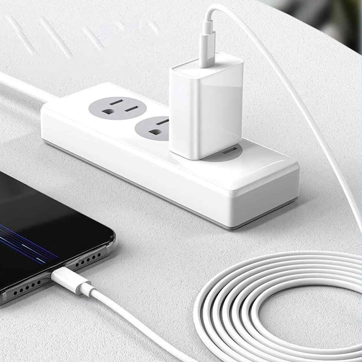 Eine weiße Steckdosenleiste mit eingestecktem Adapter, ein ladendes Telefon und ein aufgerolltes weißes Kabel.