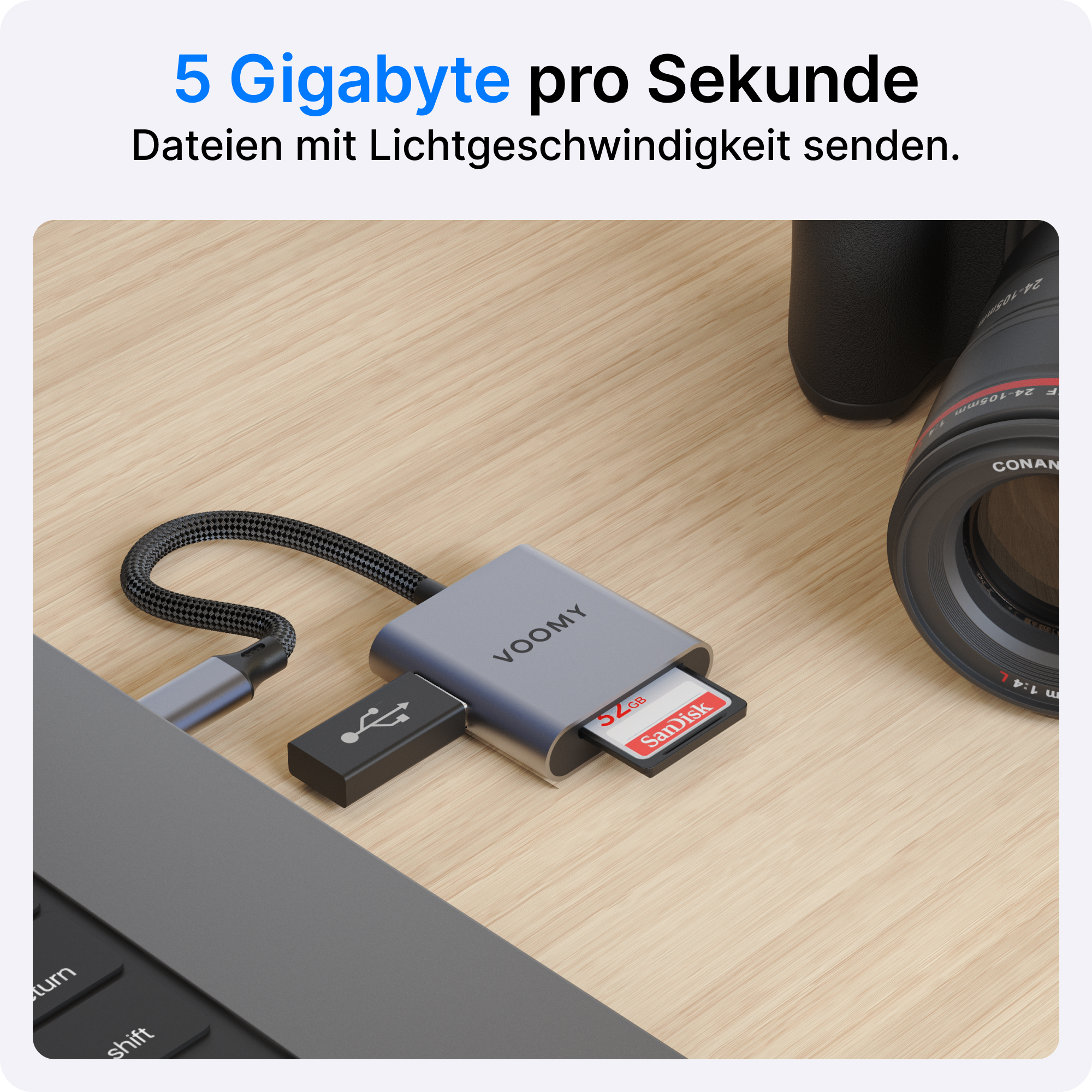 Ein graues VOOMY-Kartenlesegerät mit USB-Anschluss, eine schwarze SD-Karte und ein Laptop auf einem Holztisch.