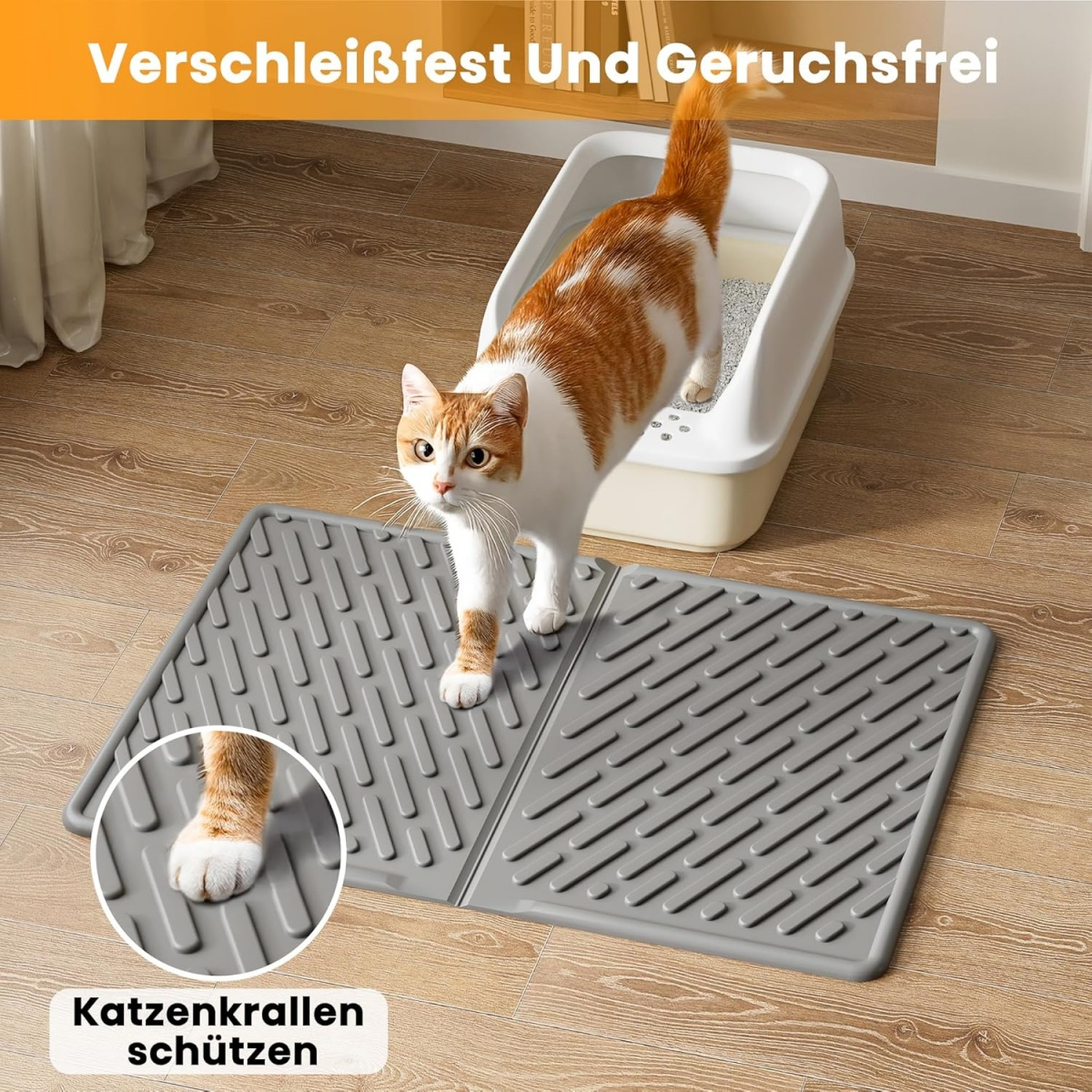 Eine Katze mit orange-weißem Fell steht auf einer grauen Matte. Im Hintergrund befindet sich eine Katzentoilette. Die Katze schaut in die Kamera.