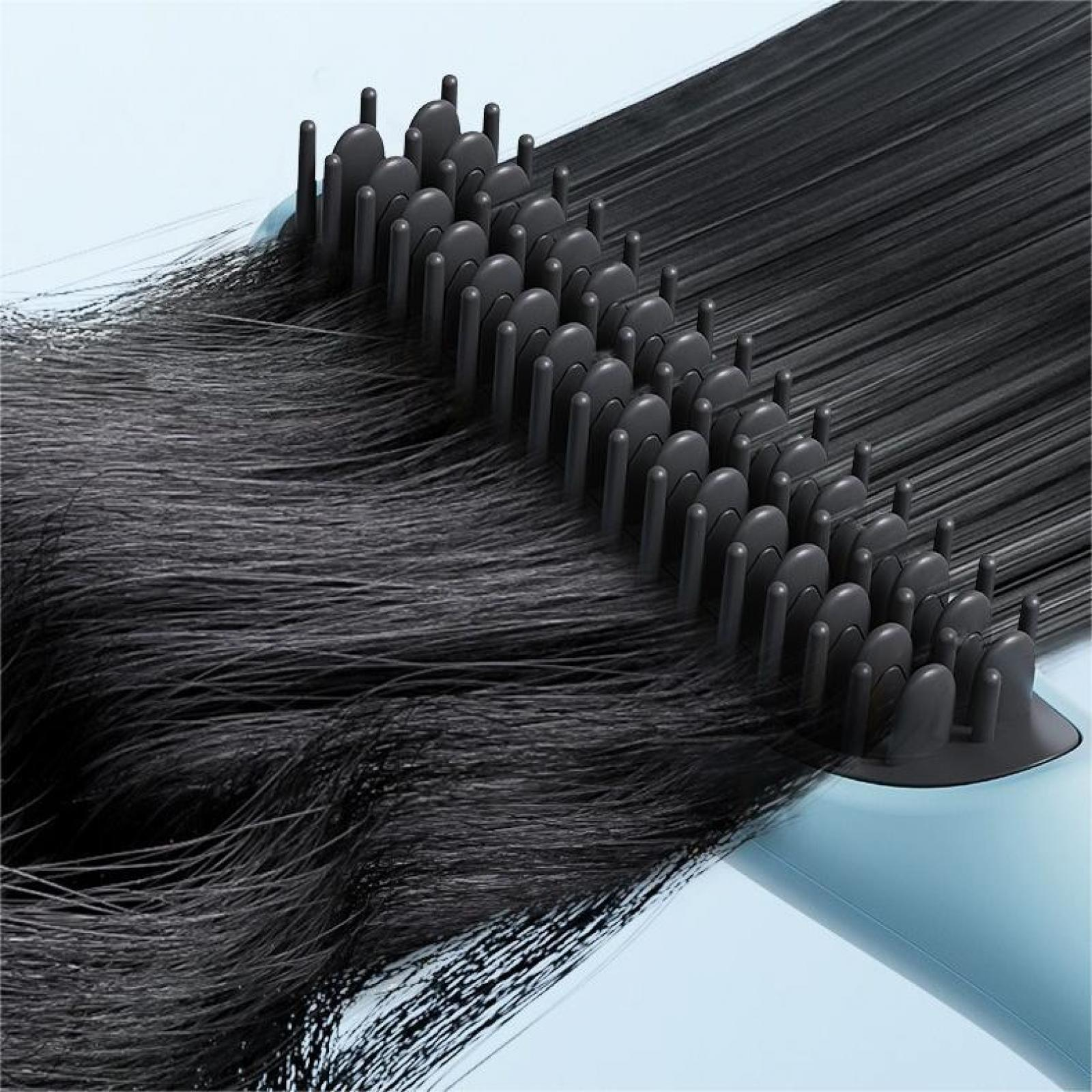 Nahaufnahme eines schwarzen Haarglätters mit schwarzen Haarsträhnen, die auf hellblauem Hintergrund geglättet werden.