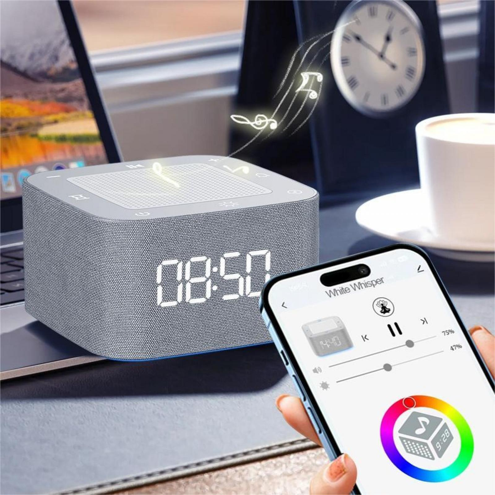Eine graue Klangmaschine mit Digitaluhr zeigt 08:50 an. Ein Telefon zeigt die App White Whisper. Im Hintergrund befinden sich eine Tasse und eine Uhr.