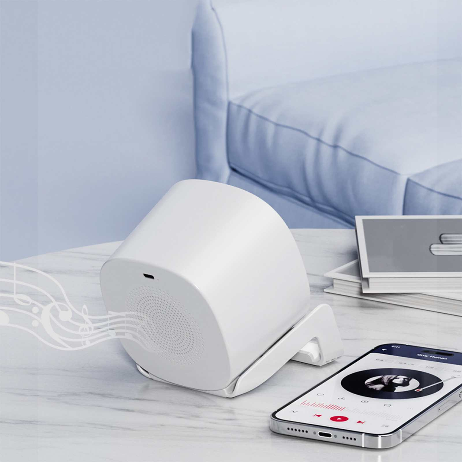 Ein weißer Lautsprecher mit Noten, ein Telefon mit einem Album und eine hellblaue Couch im Hintergrund.