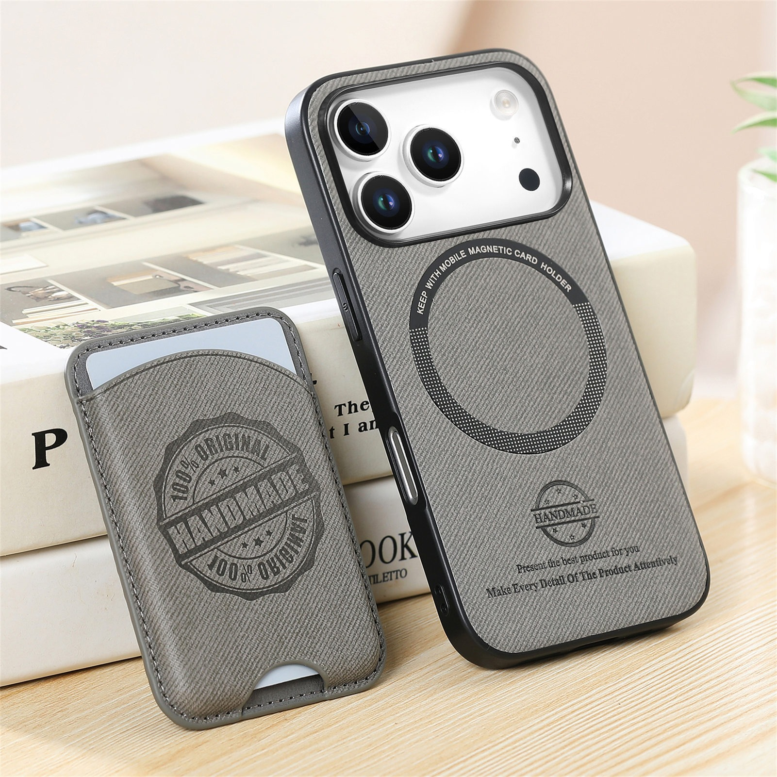Custodia per telefono e porta carte grigi con testo. Libri sullo sfondo. La custodia ha un porta carte magnetico.