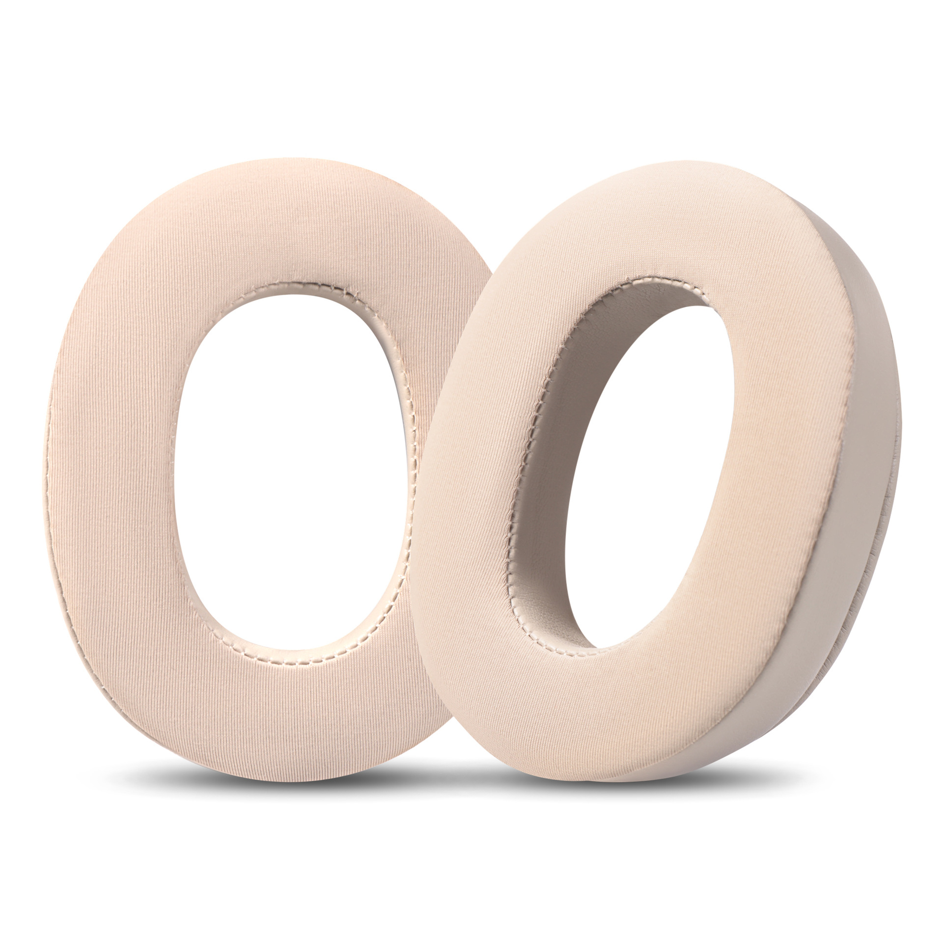 Due cuscinetti auricolari beige e circolari, forse per cuffie, sono posizionati uno accanto all'altro su sfondo bianco, con ombre.