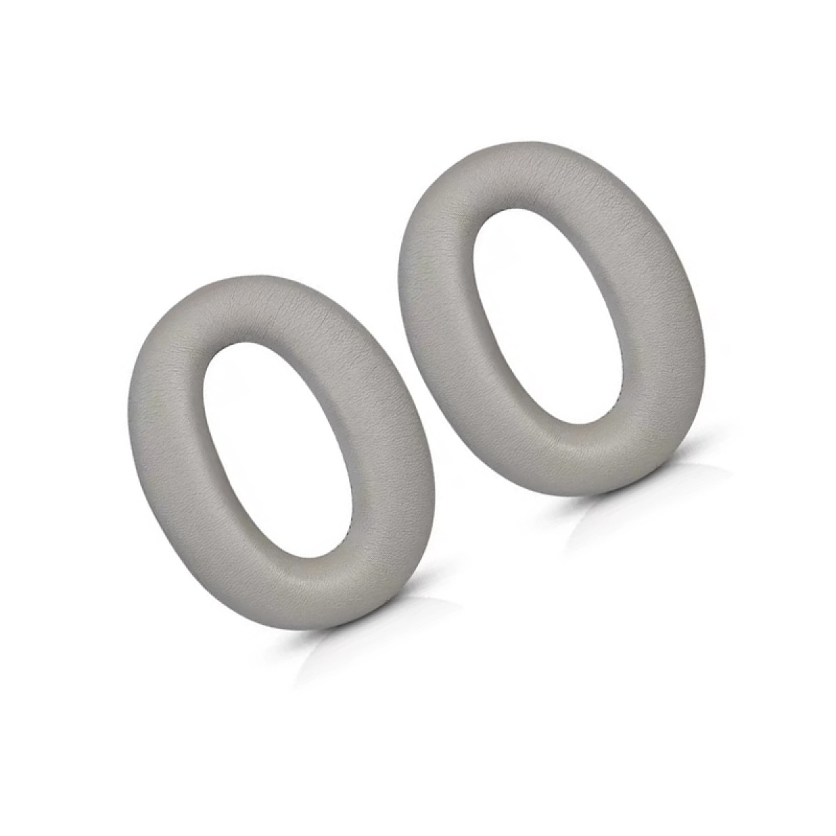 Due cuscinetti auricolari grigi a forma ovale su sfondo bianco. Sembrano per cuffie, con una leggera ombra.