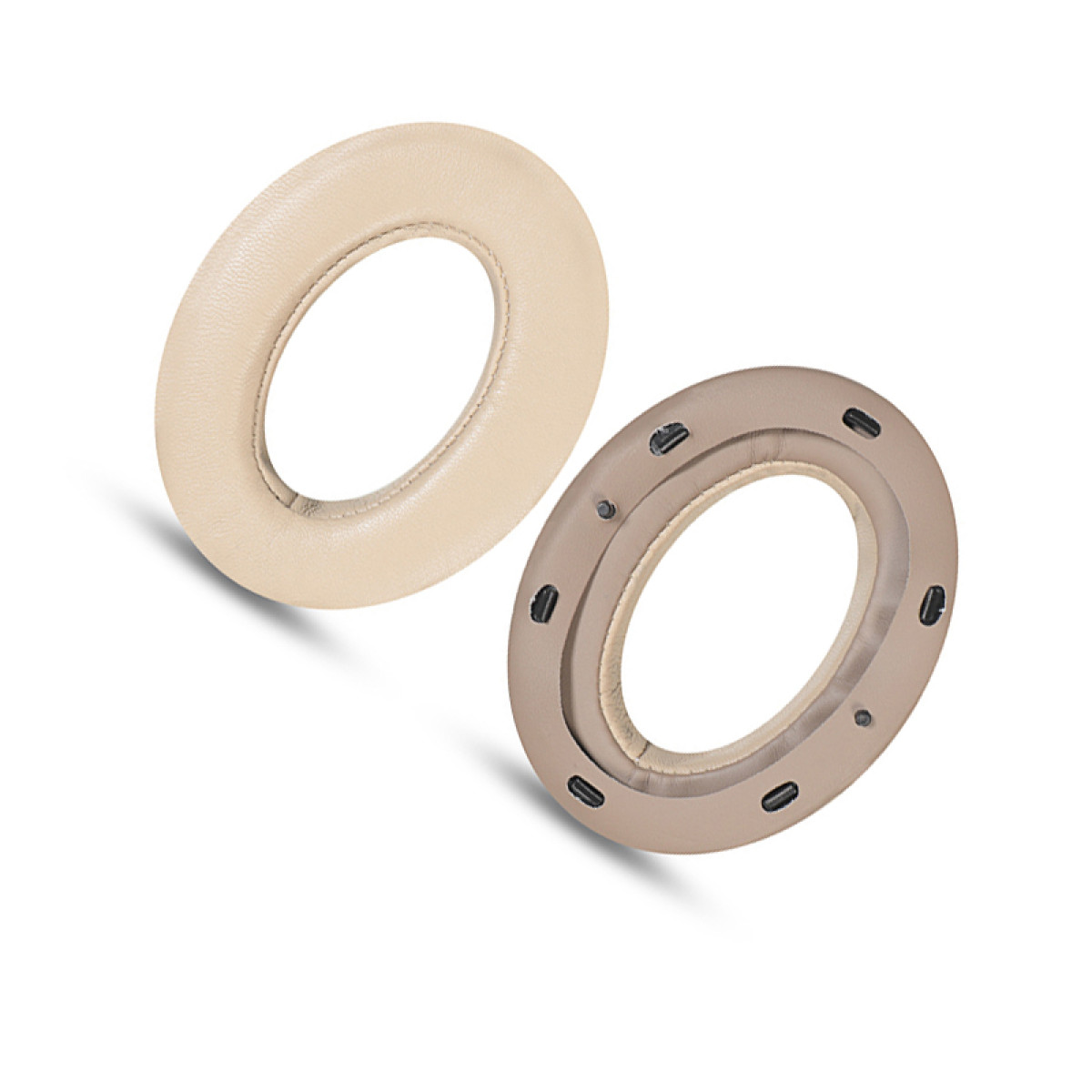 Due cuscinetti auricolari beige per cuffie. Uno è intero, l'altro ha una cornice con piccole aperture scure. Entrambi hanno forma circolare.