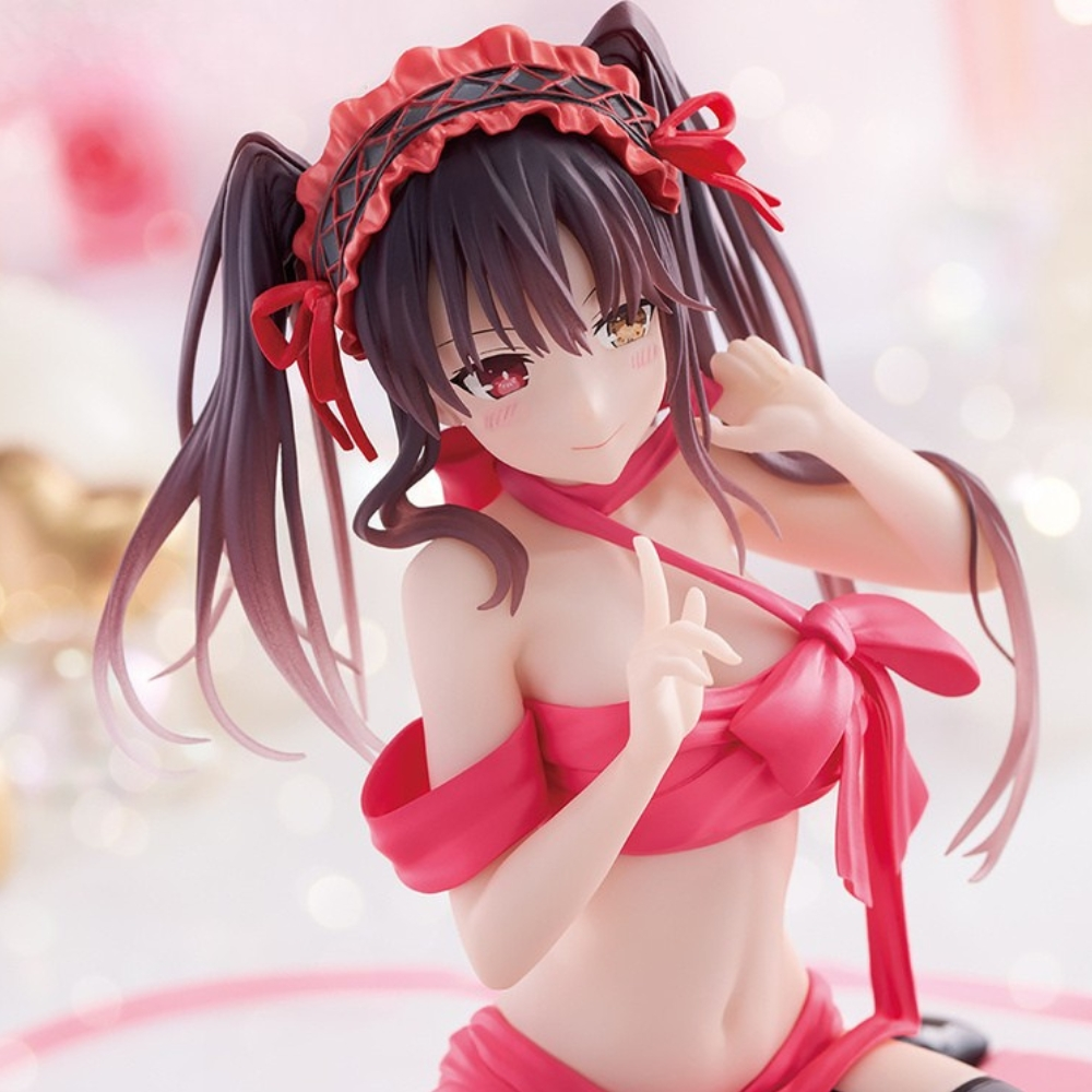 Figura anime, ragazza con capelli castani a codini, che indossa un abito a fiocco rosa e una fascia. Sorridente, con un dito puntato verso l'alto.