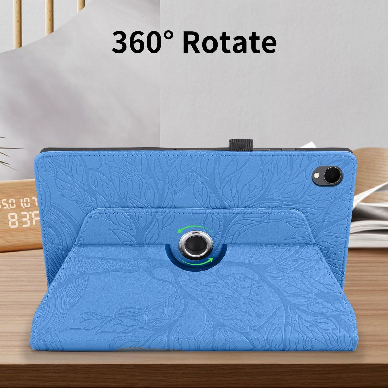 Una tableta azul con un patrón floral está en un soporte. El soporte está sobre una mesa de madera. Texto '360° Rotate' arriba.