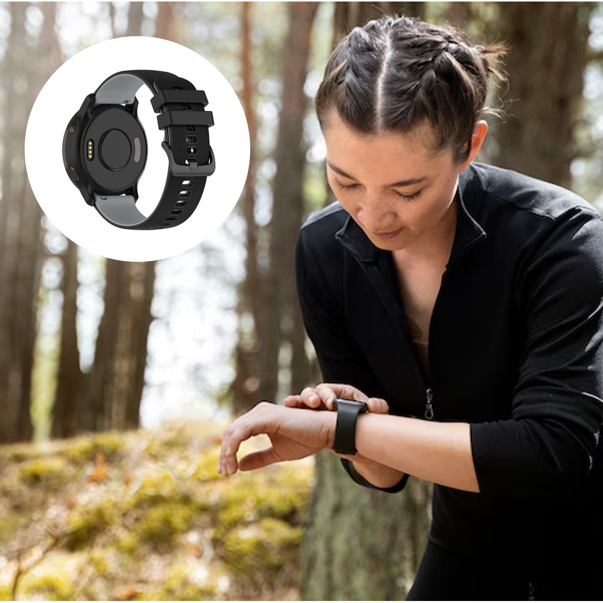 Eine Frau in schwarzer Sportkleidung überprüft eine schwarze Smartwatch im Freien. Ein Uhrendetail wird gezeigt. Waldhintergrund.