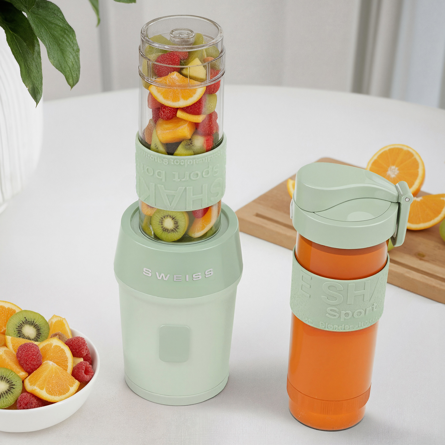 Una licuadora con frutas dentro, una botella con jugo y un cuenco de frutas sobre una superficie blanca. Dominan los colores verde y naranja.
