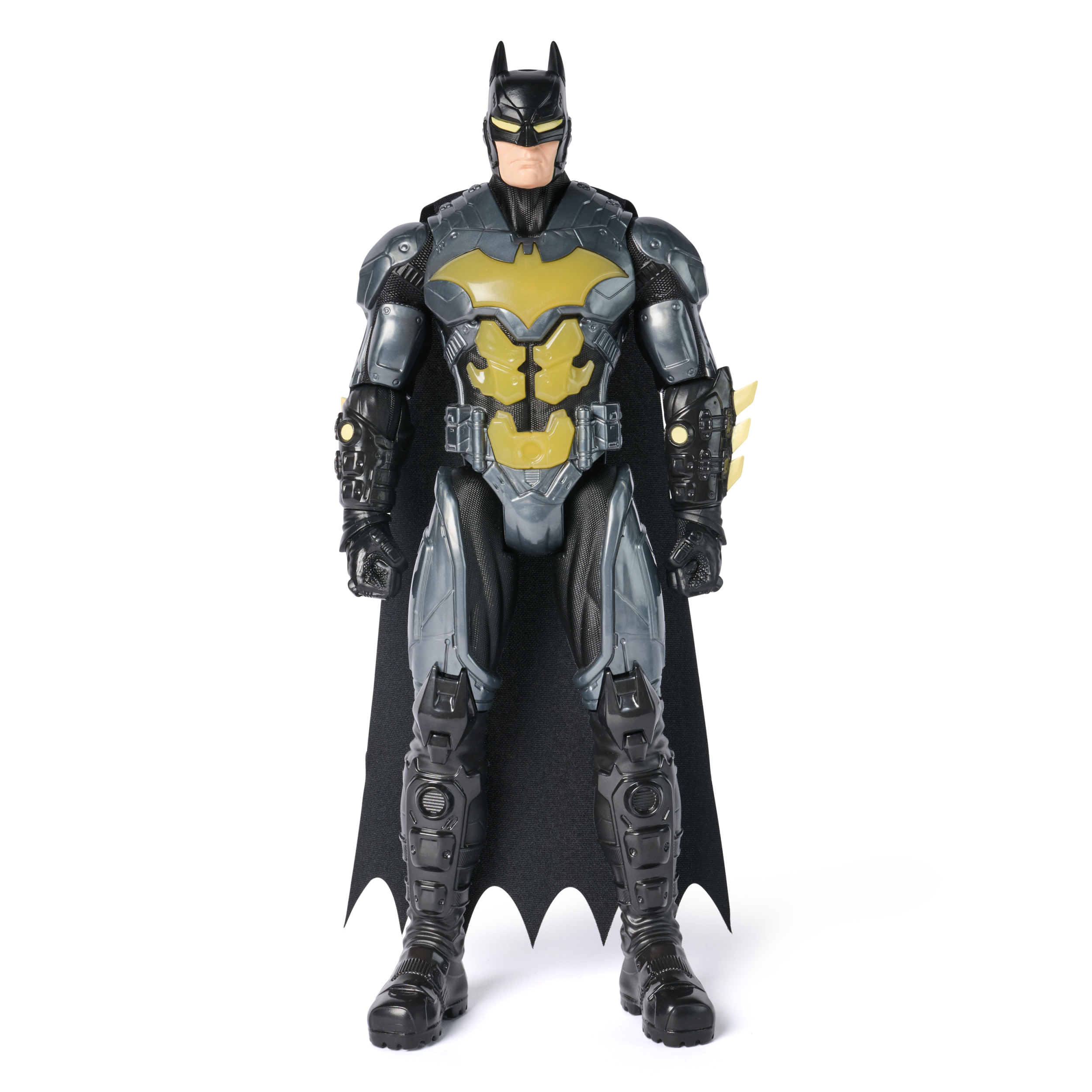 Batman-Actionfigur steht. Sie hat einen schwarzen Umhang, Stiefel und Kapuze, mit grauer und gelber Rüstung und weißem Hintergrund.
