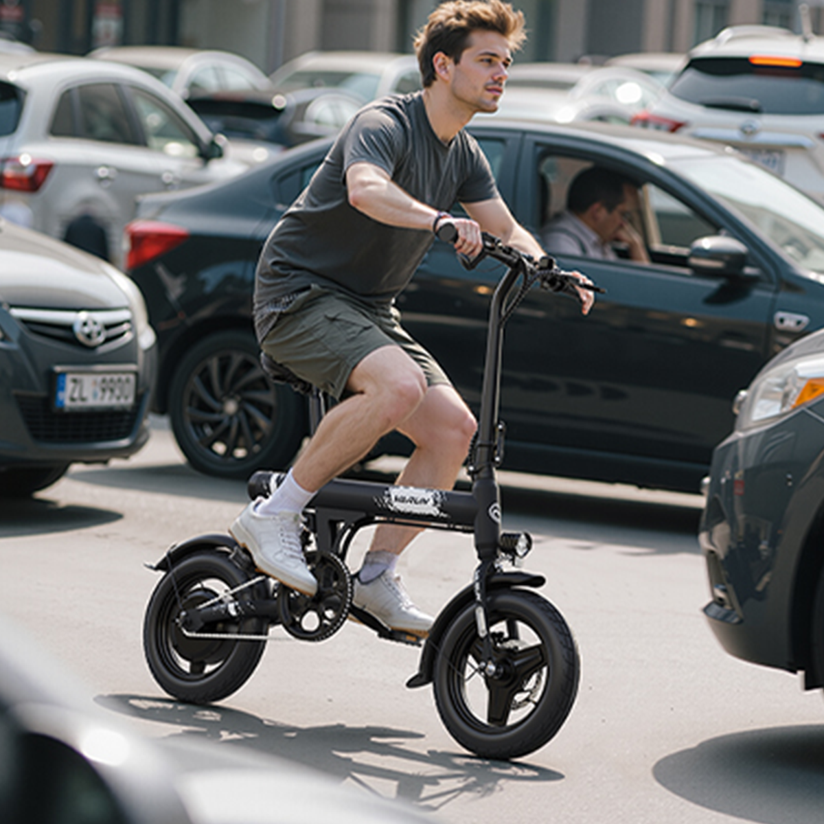 Mężczyzna jedzie czarnym rowerem elektrycznym wśród samochodów w ruchu ulicznym. Ma na sobie szorty, koszulkę i trampki. Samochody wypełniają tło.