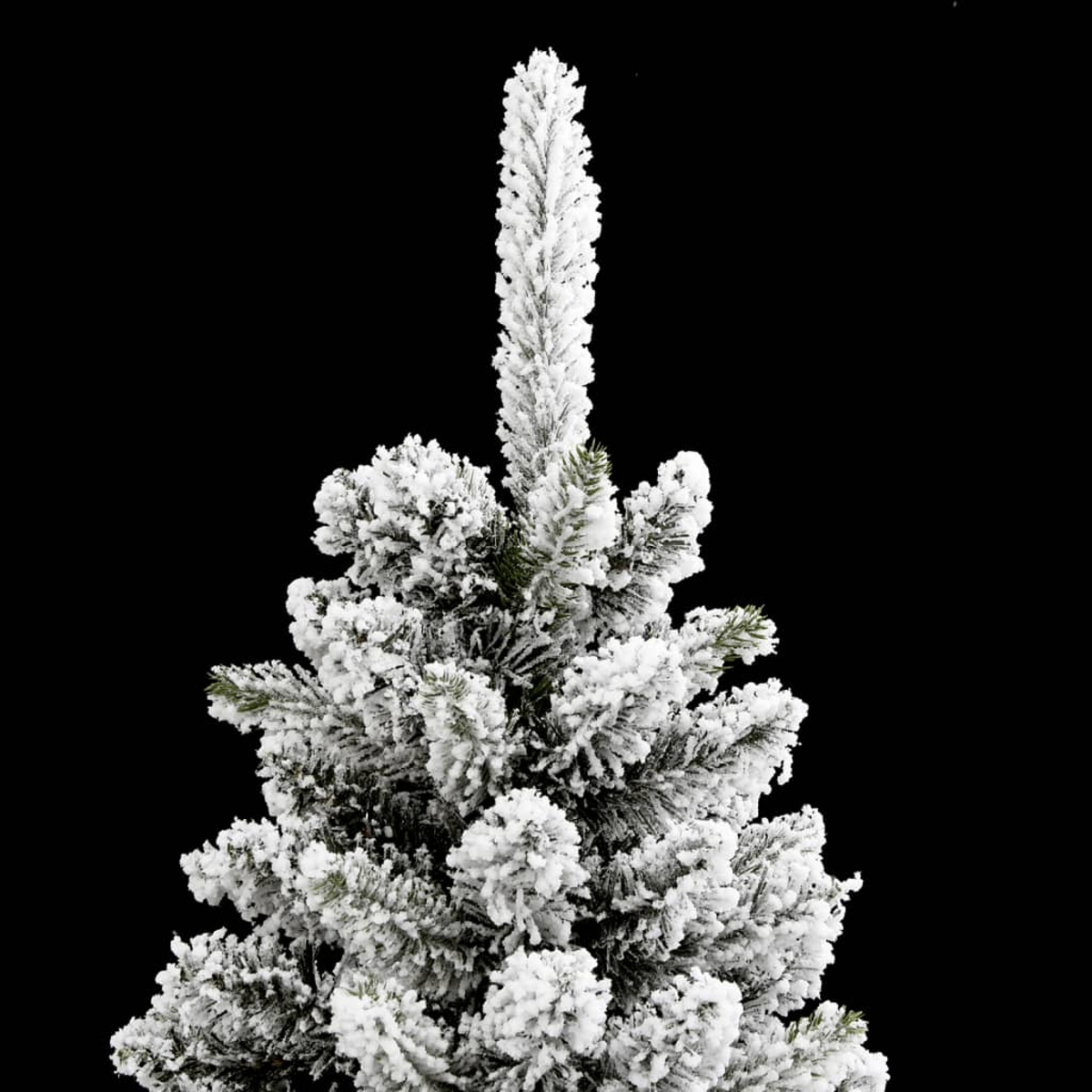 Un primo piano di un albero di Natale innevato su sfondo nero. La neve è fitta e bianca.