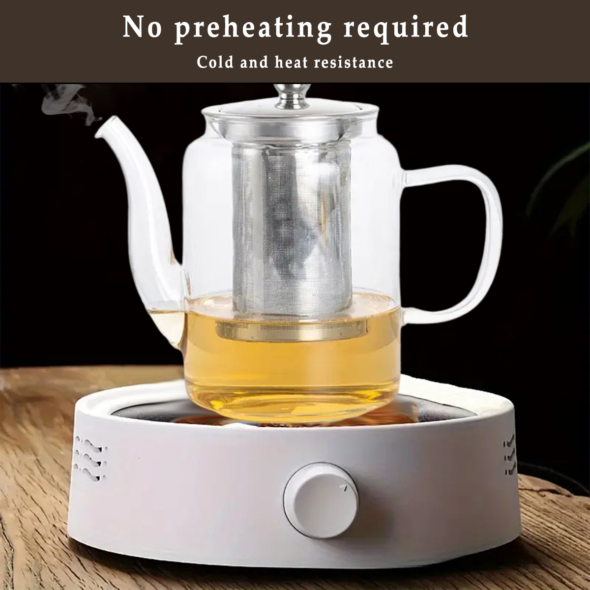 Eine Glaskanne mit Tee, der auf einem weißen Wärmer zieht. Die Teekanne hat einen Metall-Infuser und einen Griff. Dampf steigt auf.