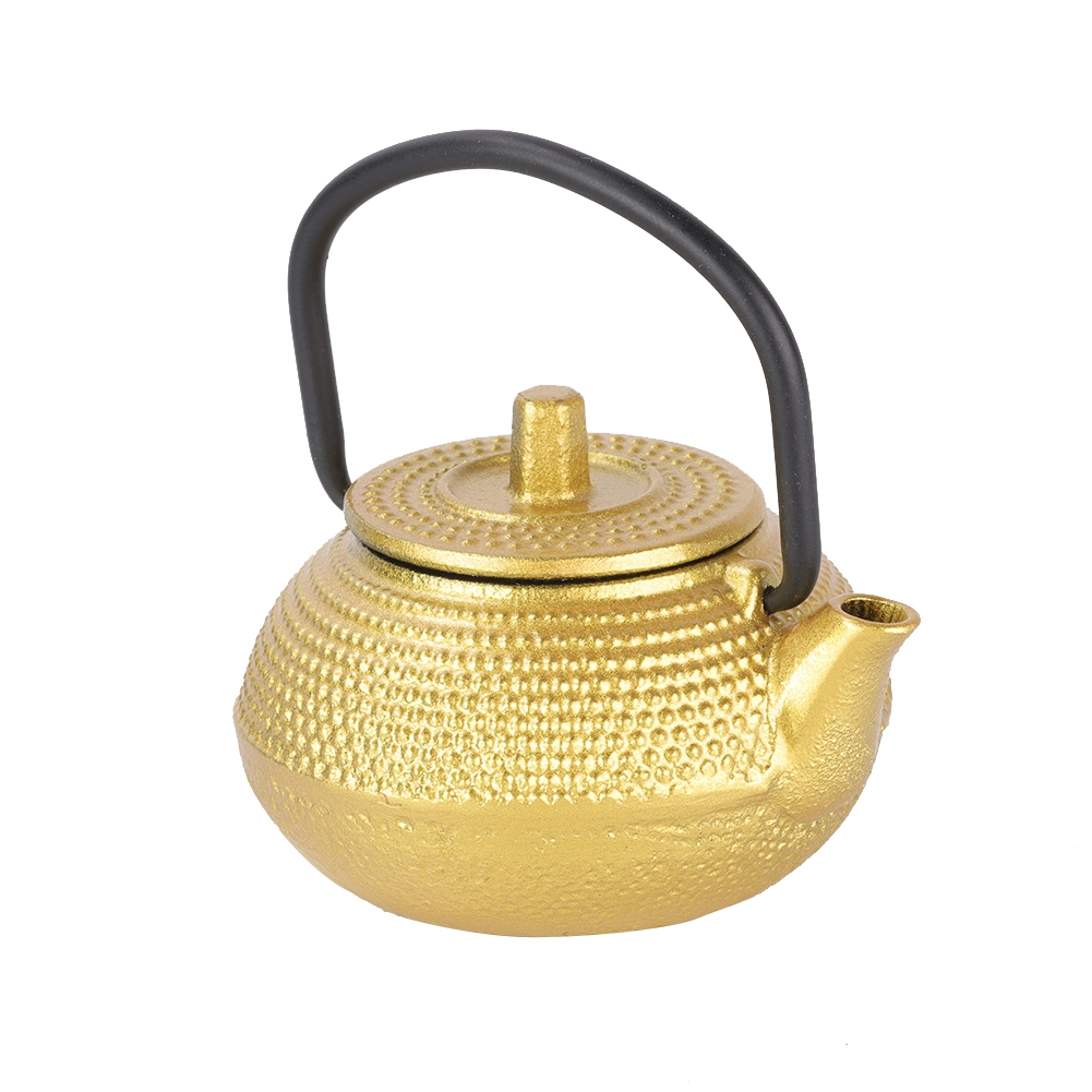 Eine goldene Teekanne mit schwarzem Griff steht auf weißem Hintergrund. Die Teekanne hat eine runde Form und einen Deckel mit kleinem Knopf.