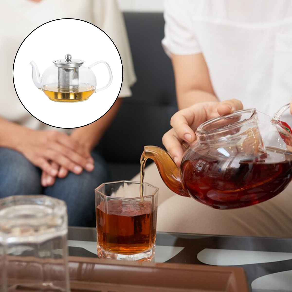 Eine Person gießt Tee aus einer Glaskanne in ein Glas. Eine Teekanne befindet sich in der oberen linken Ecke. Eine weitere Person ist im Hintergrund.