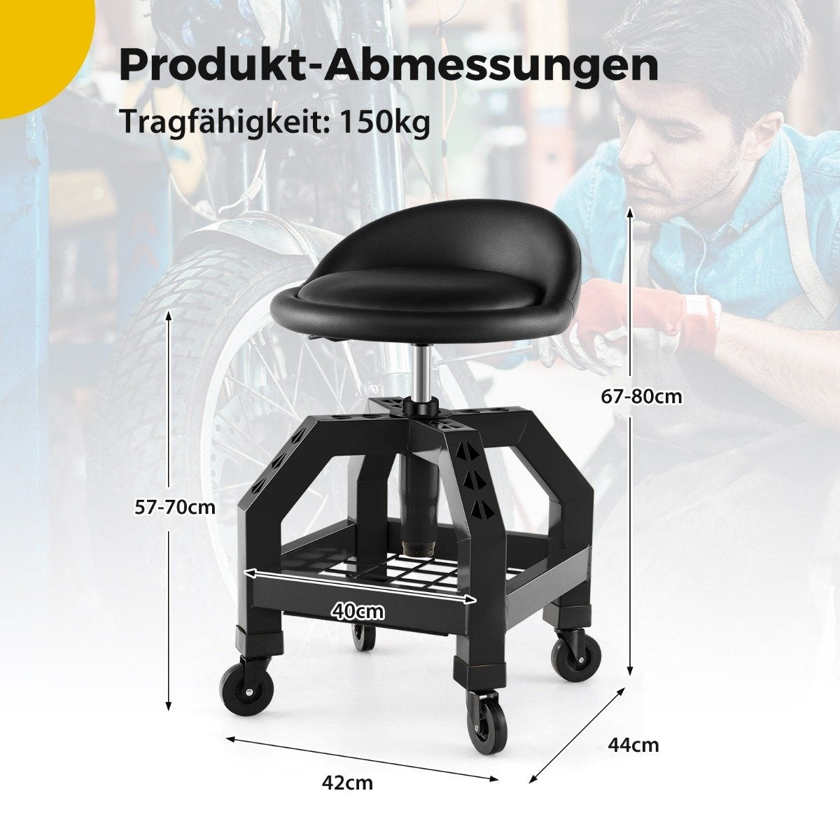 Taburete de taller rodante negro con dimensiones etiquetadas. Un hombre en el fondo. Rueda de motocicleta parcialmente visible.