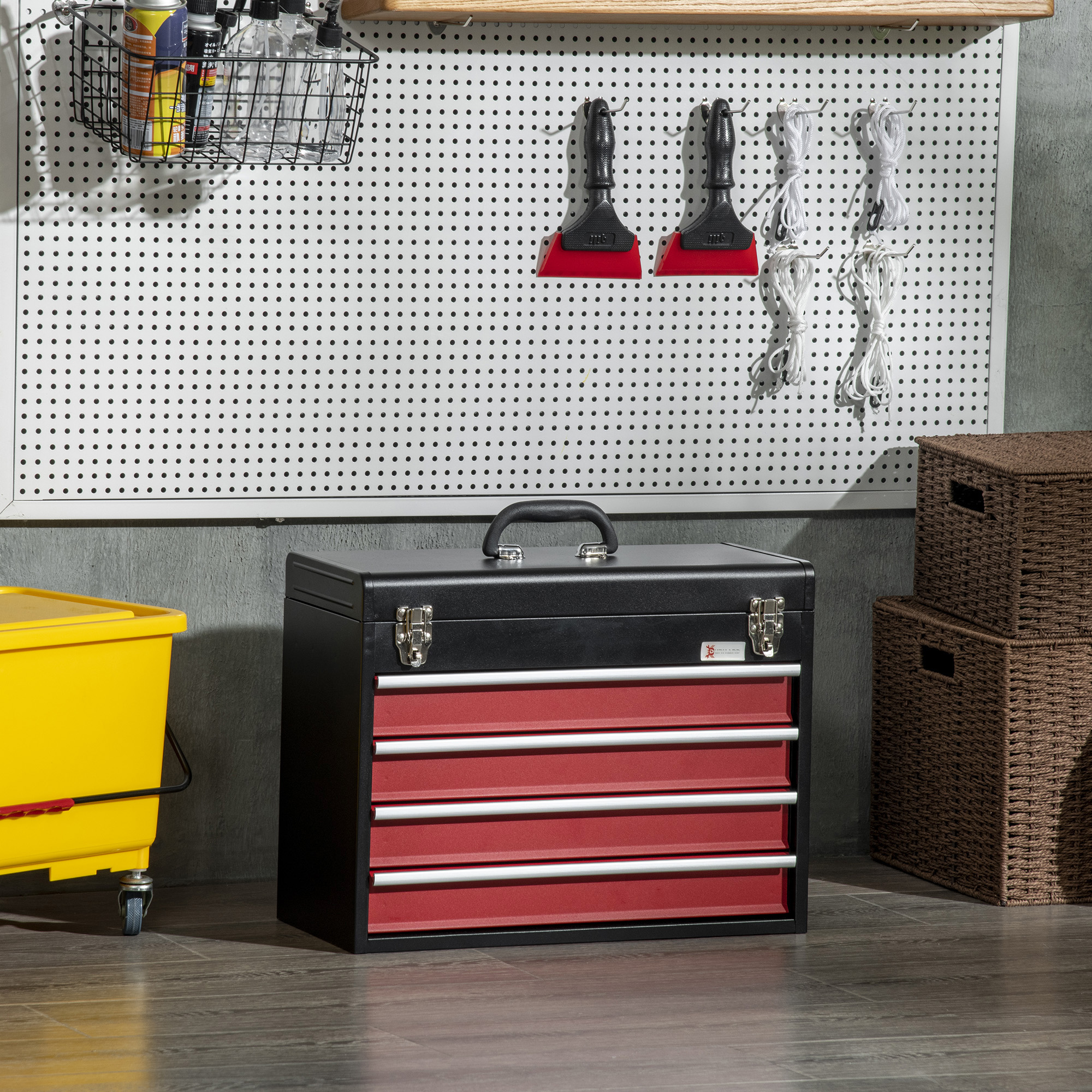 Una escena de taller con herramientas y almacenamiento. Una caja de herramientas negra, cajones rojos y un cubo amarillo son visibles.