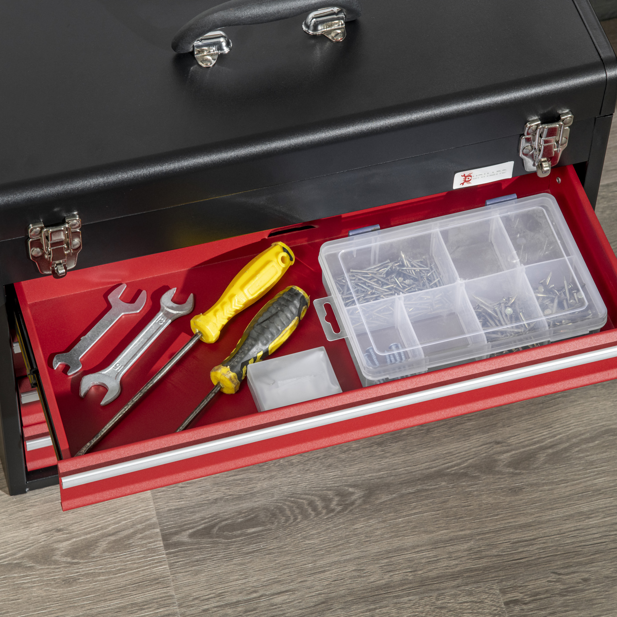 Caja de herramientas abierta con interior rojo. Llaves y destornilladores dentro, junto con tornillos y clavos.
