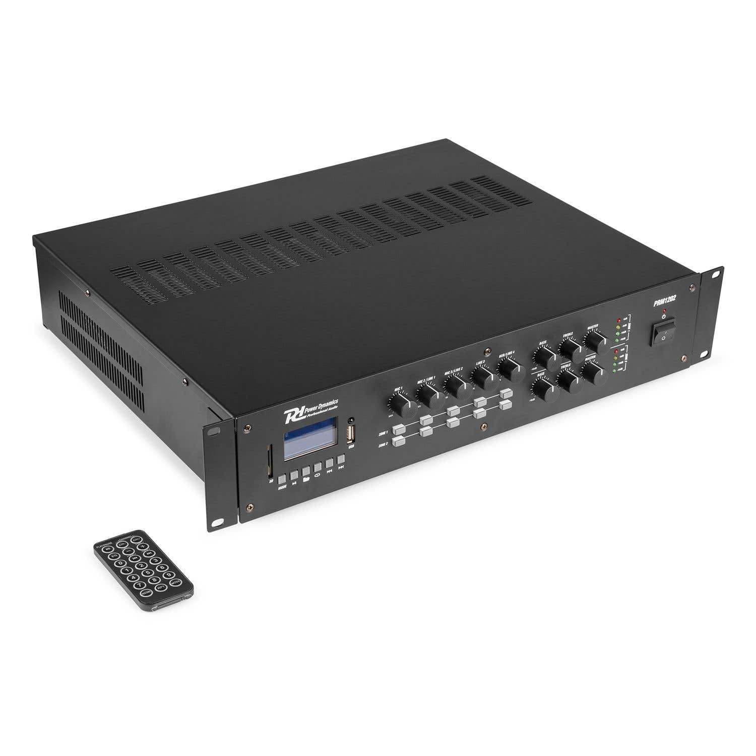 Un amplificador de audio negro con múltiples perillas y un control remoto sobre una superficie blanca.