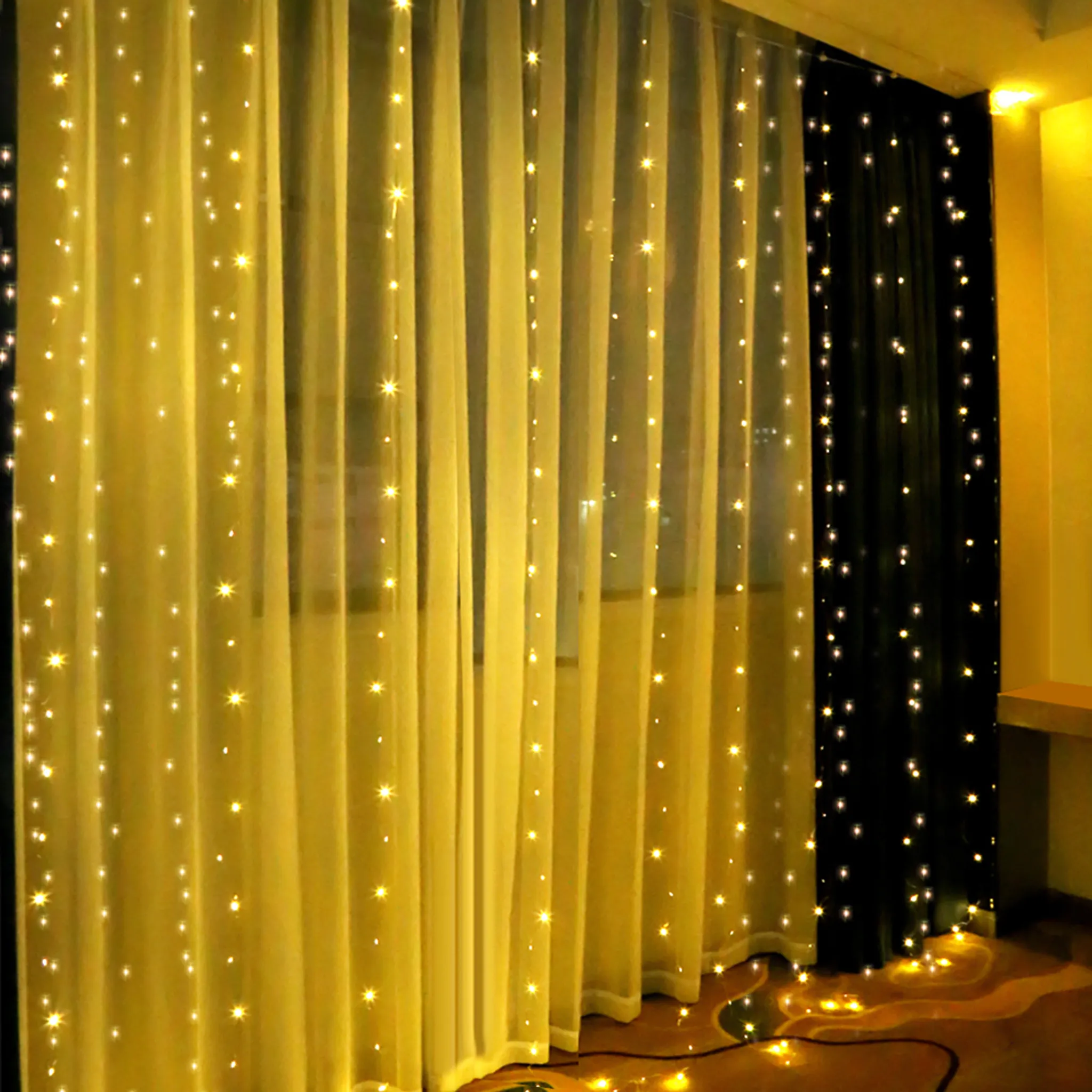 Vorhänge mit Lichterketten. Gelbe transparente Vorhänge links, schwarze Vorhänge rechts. Lichter sind verstreut.
