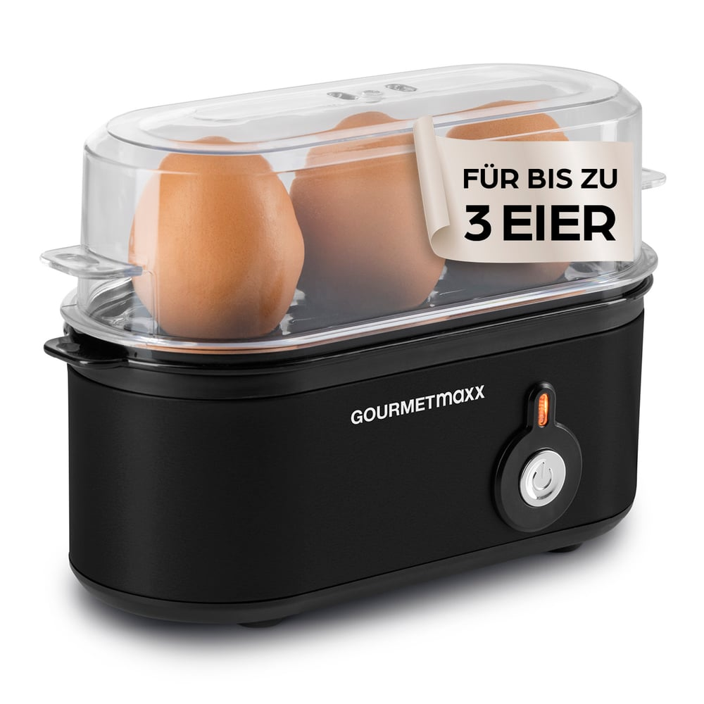 Schwarzer Eierkocher mit drei braunen Eiern. Aufkleber: 'Für bis zu 3 Eier'. Marke: 'GOURMETmaxx'.