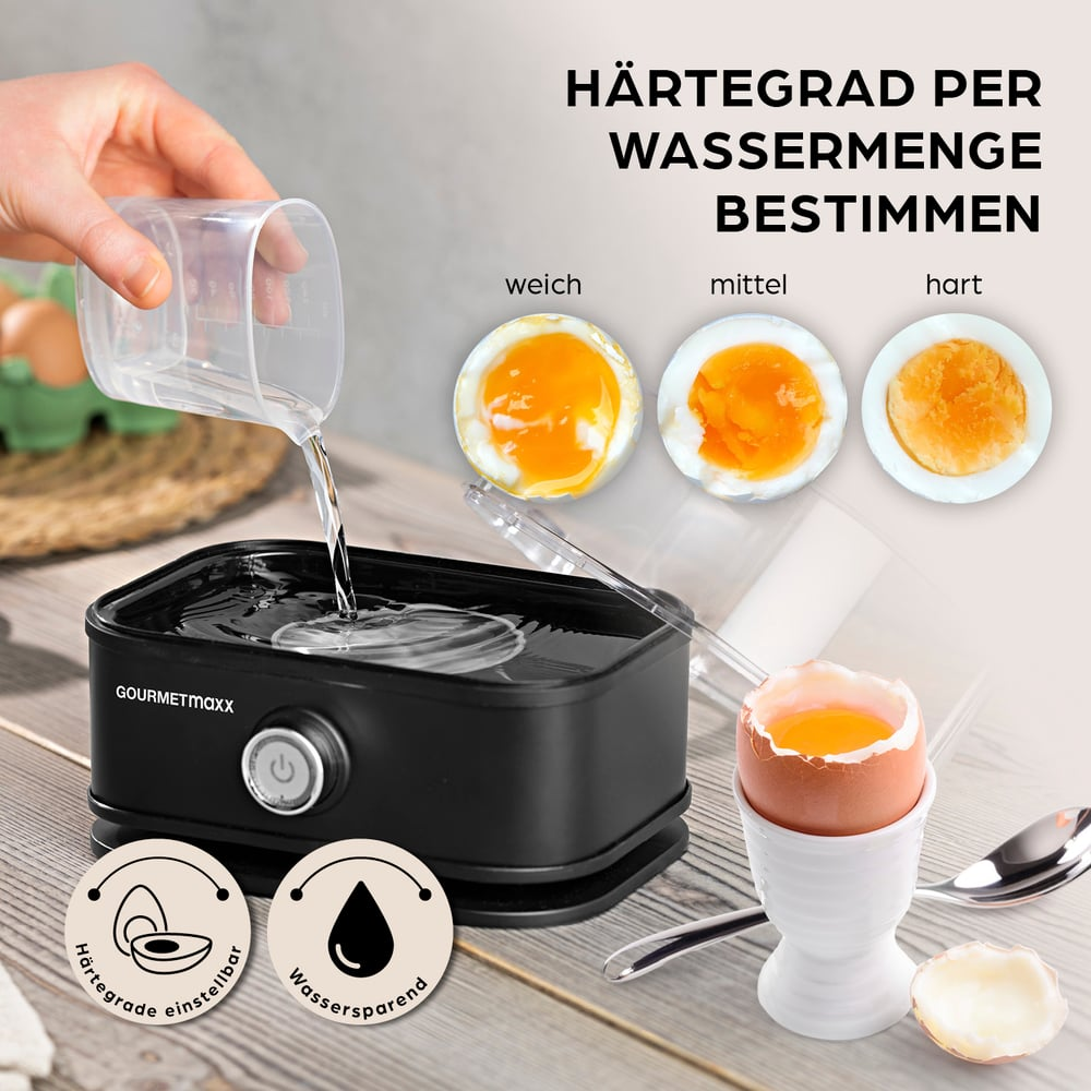 Eine Hand gießt Wasser in einen schwarzen Eierkocher. Drei halbierte Eier zeigen weiche, mittel und harte Eigelb. Ein Ei im Halter neben Löffel.