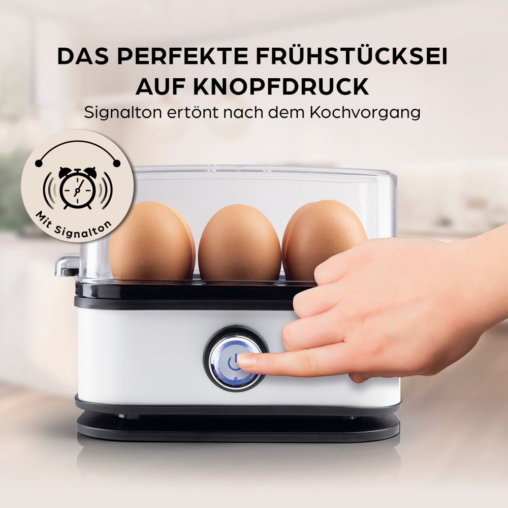 Ein Eierkocher mit drei Eiern. Eine Hand drückt den Einschaltknopf. Text: Perfekte Frühstückseier auf Knopfdruck.