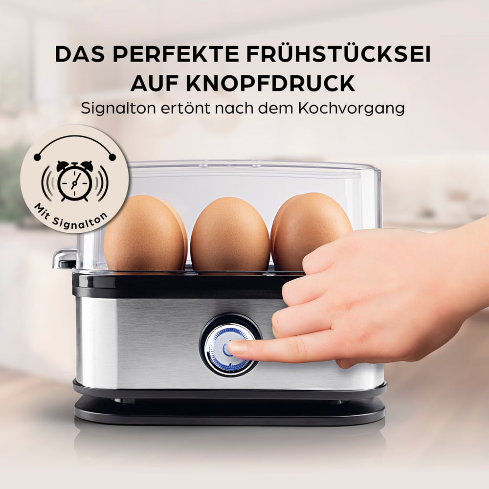 Ein Eierkocher mit drei Eiern. Eine Hand drückt den Einschaltknopf. Text: 'Perfekte Frühstückseier auf Knopfdruck'.