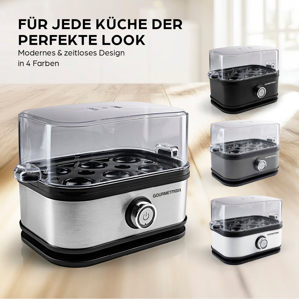 Ein Eierkocher in vier Farben: Silber, Schwarz, Grau und Weiß. Er hat einen transparenten Deckel und einen Einschaltknopf. Die Marke ist Gourmetmaxx.