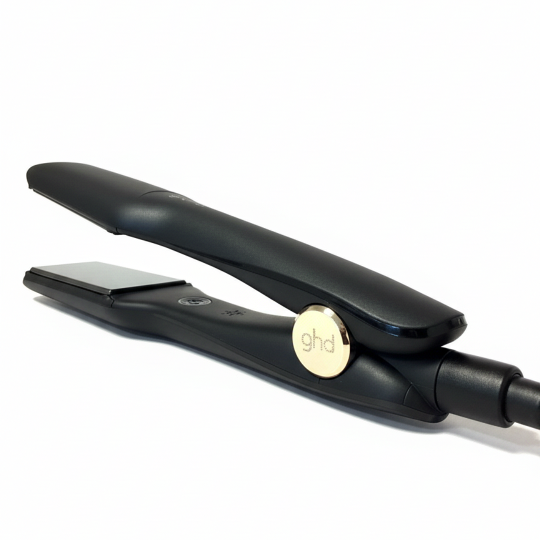 Ein schwarzes GHD-Haarglätteisen ist geöffnet und zeigt eine silberne Platte. Es hat einen goldenen Knopf mit dem Markennamen und ein schwarzes Kabel.