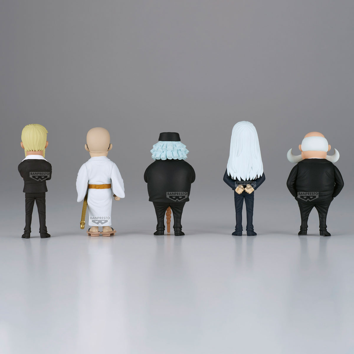 Cinque figurine in fila, di spalle. Sono di persone diverse. Lo sfondo è grigio e il pavimento è bianco.