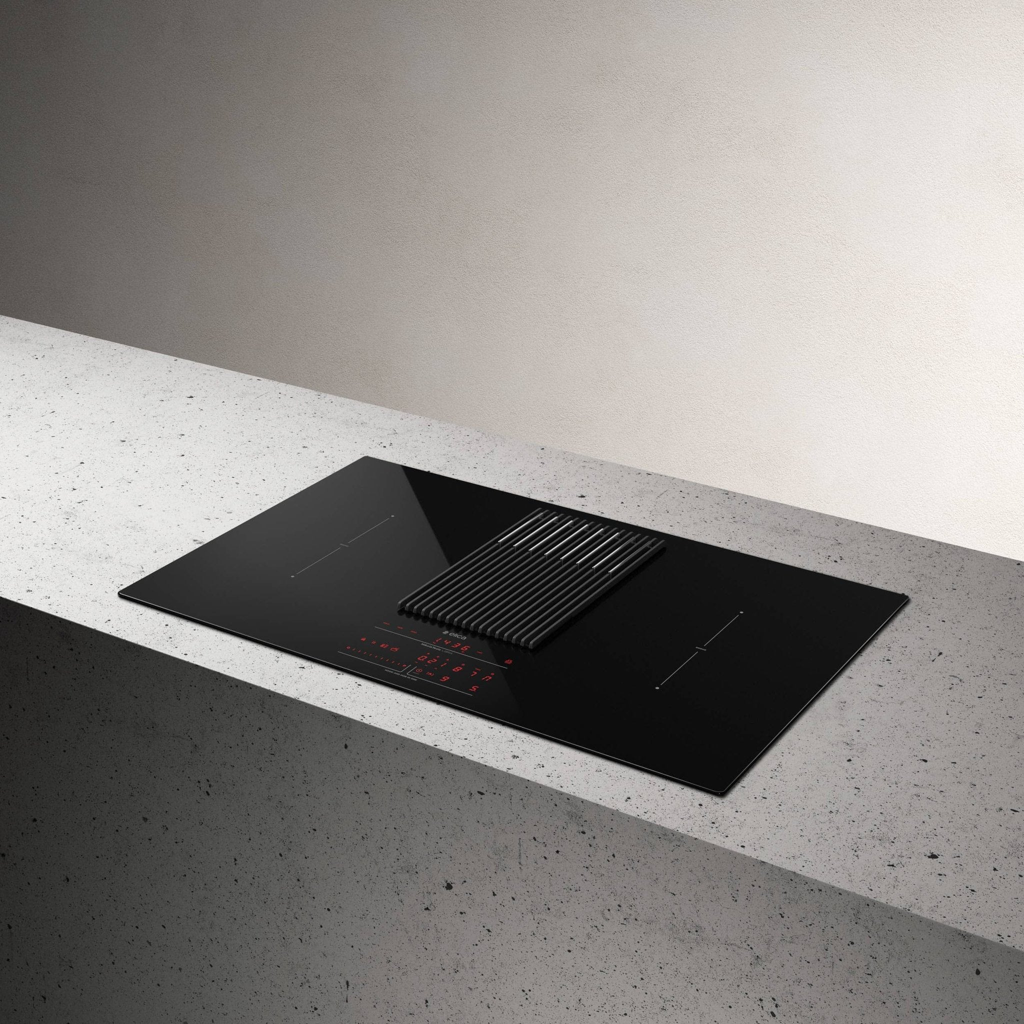 Czarna płyta indukcyjna z wbudowanym okapem na betonowej powierzchni. Czerwony wyświetlacz, czarna osłona, białe tło.